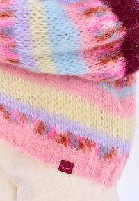 Kolorowy sweter z dzianiny, z mieszanką różowych, niebieskich, lawendowych i żółtych pasków, o miękkiej, puszystej fakturze oraz z małą metką przy dolnym brzegu.