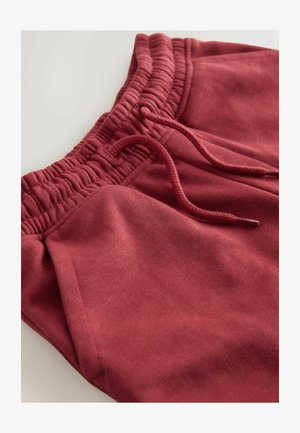 Pantaloni sport bordo cu talie texturată, închidere cu șnur și buzunare frontale; material moale, din amestec de bumbac.