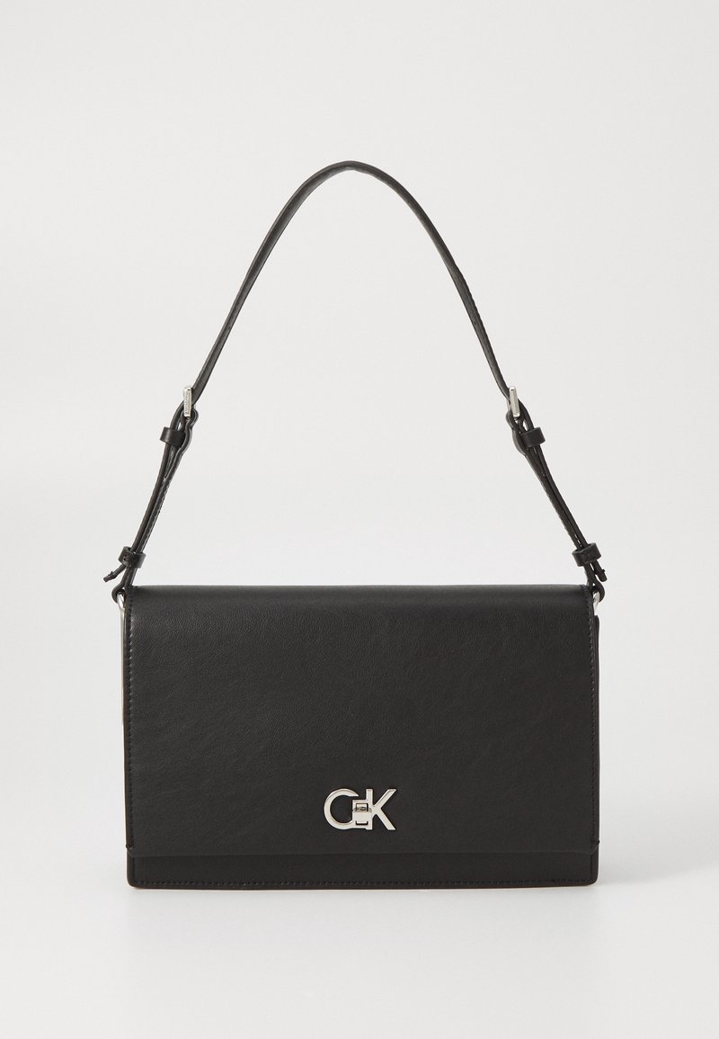 Sac bandoulière en cuir noir avec bandoulière réglable et fermoir argenté avec logo CK sur le rabat avant.