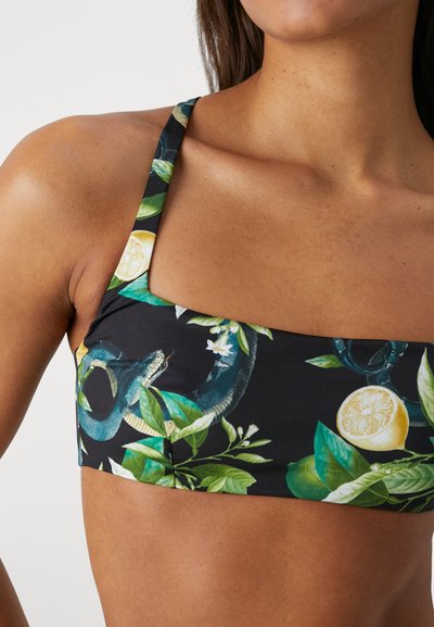 Bikini horná časť s kvetinovým vzorom v čiernej farbe so zelenými listami, citrónmi a vzorom hada. Má široké ramienka a štvorcový výstrih.