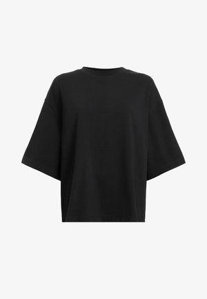 T-shirt nera oversize in cotone, con maniche corte, collo rotondo, texture morbida e un design dalla vestibilità rilassata.