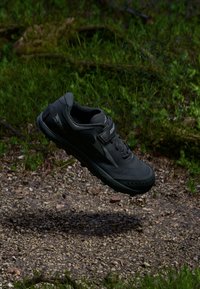 Black outdoor shoe with a textured upper, lace closure, and reinforced toe. It features ventilation holes and a durable sole.