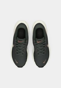 Crne i tamnozelene sportske cipele s mrežastim gornjim dijelom, podstavljenim ovratnikom, vezanjem i kontrastnim bež potplatom. Sadrže suptilne Swoosh logotipe.