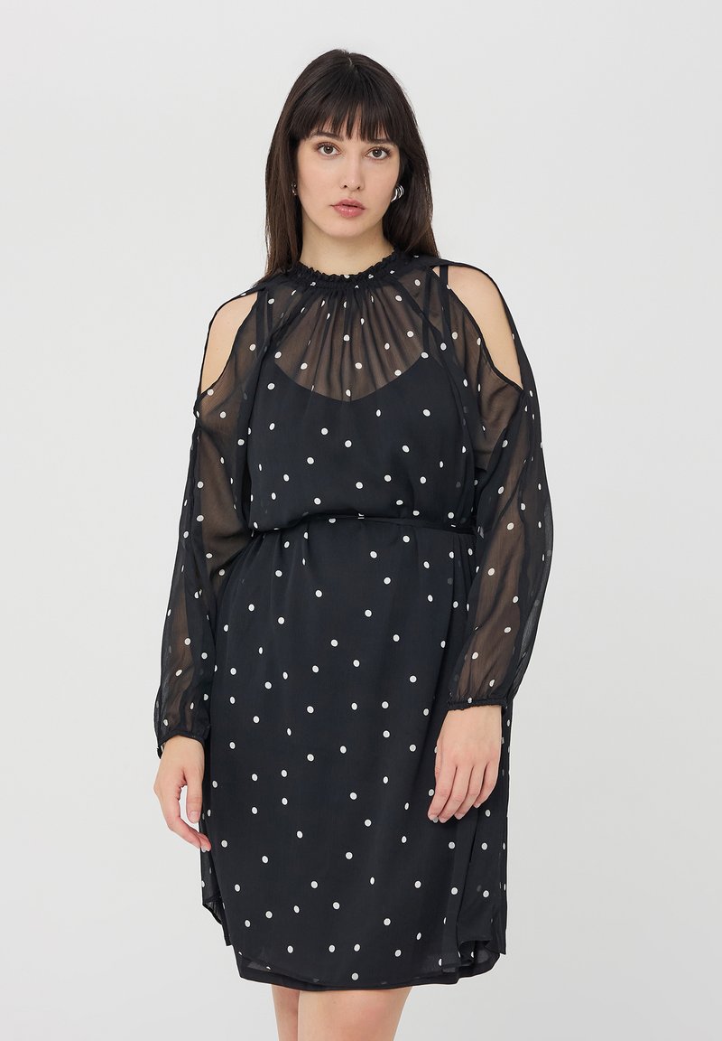 Abito nero a pois con maniche lunghe trasparenti, scollatura arricciata e dettagli con spalle scoperte. Tessuto morbido e leggero con una vestibilità fluida.