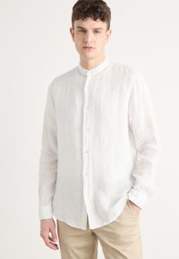 Witte linnen langekleur shirt met een Mandarin kraag, knoopsluiting aan de voorkant, en een iets relaxte pasvorm. Gestructureerde, lichte stof.
