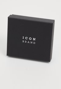 Sort boks med mat overflade, der har hvid tekst, som siger "ICON BRAND." Rektangulær form, glat tekstur, ingen ekstra mønstre eller accenter.