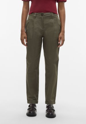 Pantalons vert olive avec plis à l'avant, fermeture à bouton, poches latérales et coupe fuselée, associés à des mocassins noirs.