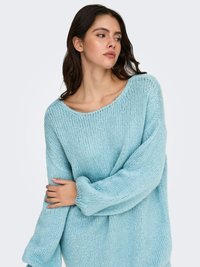 Light blue knitted sweater with a loose fit, wide neck, and long sleeves, featuring a soft texture and subtle ribbing detail.