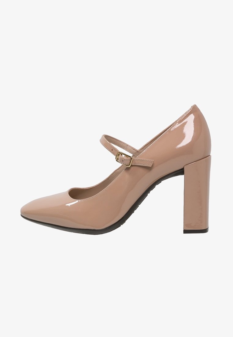 Lackläder Mary Jane-klack i ljusbeige med spetsig tå, justerbar rem och chunky blockklack. Slät, glänsande yta.