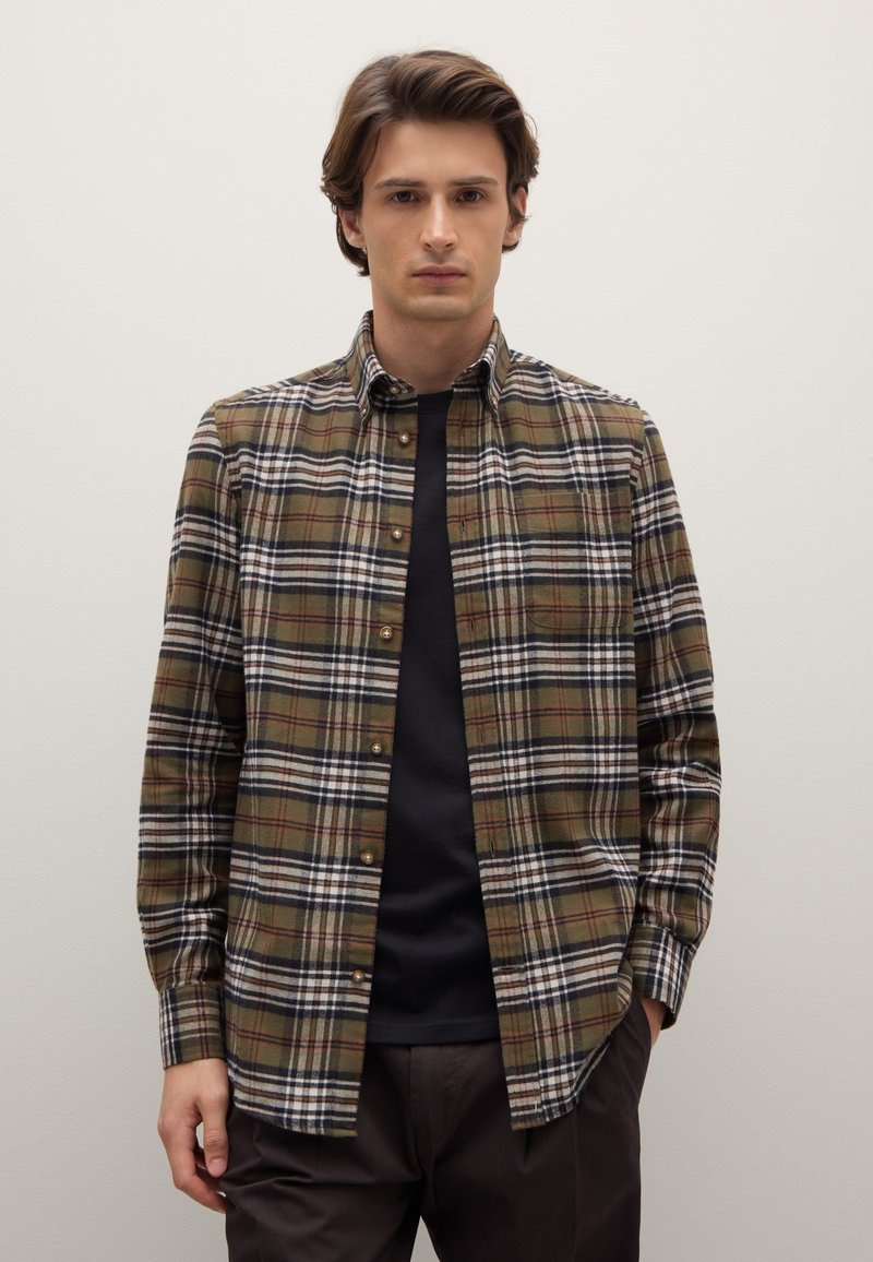 Braun-grünes kariertes Hemd mit Button-Down-Kragen, verziert mit weißen und roten Linien, getragen über einem schwarzen Hemd. Strukturierter Stoff, lässiges Design.