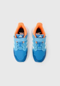 Chaussures de sport bleues avec des accents blancs, tige en maille, bout arrondi et sangle réglable. Doublure intérieure orange vif et col rembourré.