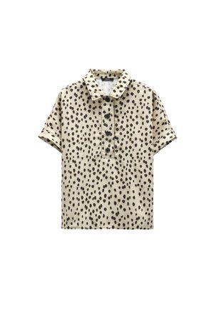 Beżowa koszula z krótkim rękawem w czarne nieregularne kropki, z kołnierzykiem i czterema czarnymi guzikami na środku przodu.