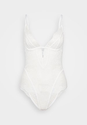 Valkoinen pitsinen bodysuit syvällä V-kaula-aukolla, ohutolkaimilla, kukkakuviolla ja läpikuultavalla materiaalilla; edessä avausyksityiskohta.