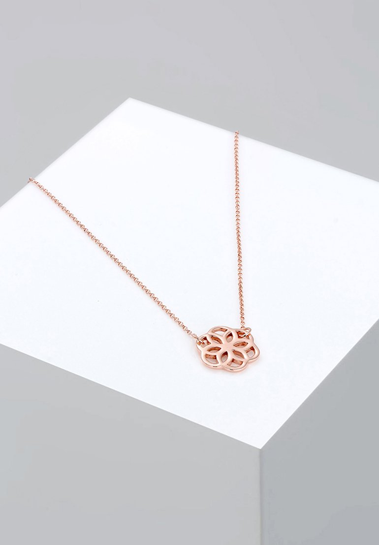 Rosaguld kæde med vedhæng i blomsterdesign, der har et indviklet udskæringsmønster på en tynd kæde. Glat tekstur og delikate led.