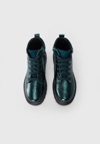 Chaussures en cuir métallique teal avec un bout rond, dotées d'un laçage à l'avant, d'une fermeture à glissière sur le côté et d'une semelle noire texturée.