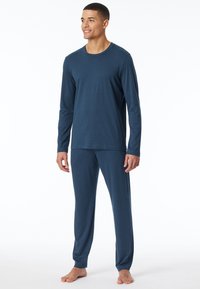 Herren-Schlafanzug im Dunkelblau, aus weichem Stoff. Enthält ein langärmeliges Oberteil mit Rundhalsausschnitt und passende Hose mit elastischen Bündchen.