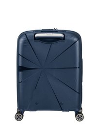 Valigia rigida blu navy con una texture lineare e un design geometrico. Caratterizzata da una maniglia superiore e quattro ruote per la mobilità.