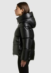 Giubbotto imbottito nero con finitura lucida, cappuccio oversize e tasca frontale. Presenta una chiusura con zip e dettagli sui pannelli laterali.