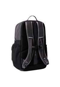 Must seljakott hallide detailide, polsterdatud rihmade, võrkväljakutega küljetaskute ja pealmise sangaga. Omaduseks on sile, ristkülikukujuline disain ja reguleeritavad pandlad.