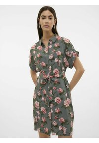 Abito camicia floreale in tessuto verde, caratterizzato da rose pink, maniche corte, davanti con bottoni e vita legata per una silhouette attillata.