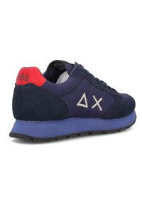 Sneakers blu navy con materiali in camoscio e rete. Presentano un tallone rosso a contrasto, una suola intermedia viola e un logo bianco sul lato.