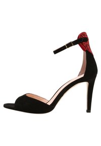 Czarne zamszowe sandały na wysokim obcasie z odkrytymi palcami, paskiem na kostce, złotym zapięciem i czerwoną brokatową ozdobą na tyle obcasa.