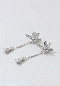 Los pendientes de gota en plata presentan un conjunto de piedras preciosas de corte marque con acentos en forma de lágrima, conectados por delicadas cadenas.