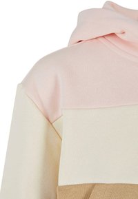 Felpa color block con pannelli rosa, crema e beige. Tessuto morbido con una finitura texture. Dettaglio del cappuccio sul collo.