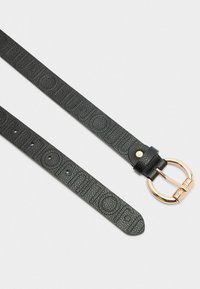Zwarte leren riem met textuur en een reliëflogo, voorzien van een cirkelvormige gesp in goudkleur en verstelbare inkepingen. Plat ontwerp, minimale details.