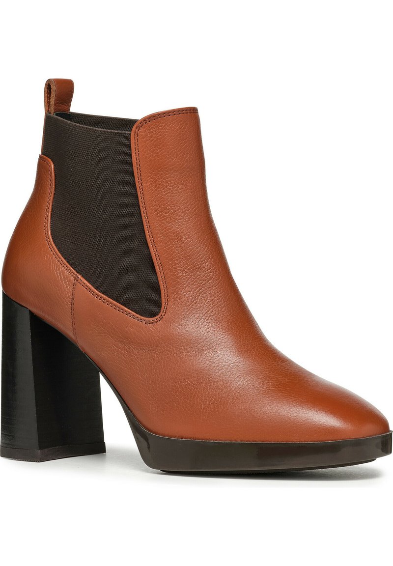 Botte de cheville en cuir marron avec des panneaux élastiques noirs, bout pointu et large talon noir. Texture lisse et détails de couture minimaux.