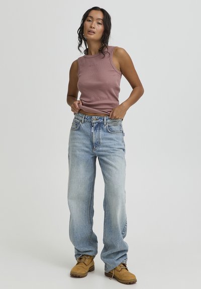 Light purple ribbed tank top, loose blue denim jeans, and tan boots. Smooth fabric and relaxed fit, with a basic design and visible stitching.