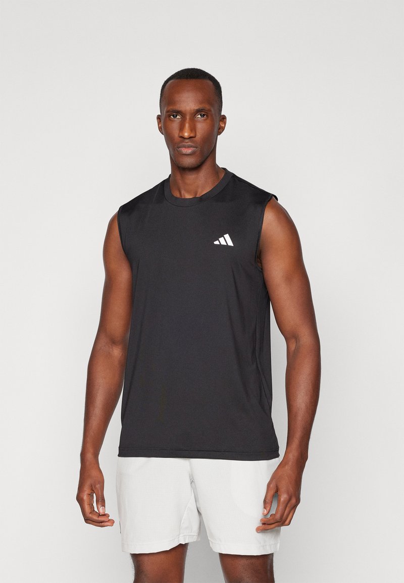 Camiseta atlética sin mangas negra con cuello redondo, que presenta un logo blanco en el pecho izquierdo. Tejido ligero y que absorbe la humedad.