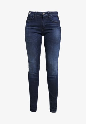 Jeans ajustados en denim oscuro con una textura suave. Presentan un diseño clásico de cinco bolsillos y cierre con botón de metal.