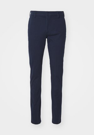 Pantalon bleu marine avec une texture lisse, design ajusté, passants de ceinture, fermeture à bouton et poches avant. Sans motifs ni accents visibles.