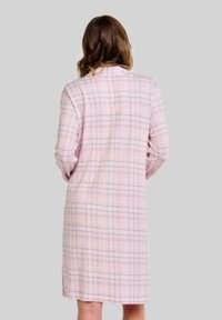 Camisón de manga larga en patrón de cuadros rosa claro, hecho de una tela suave, con un corte recto y aberturas laterales en el dobladillo.
