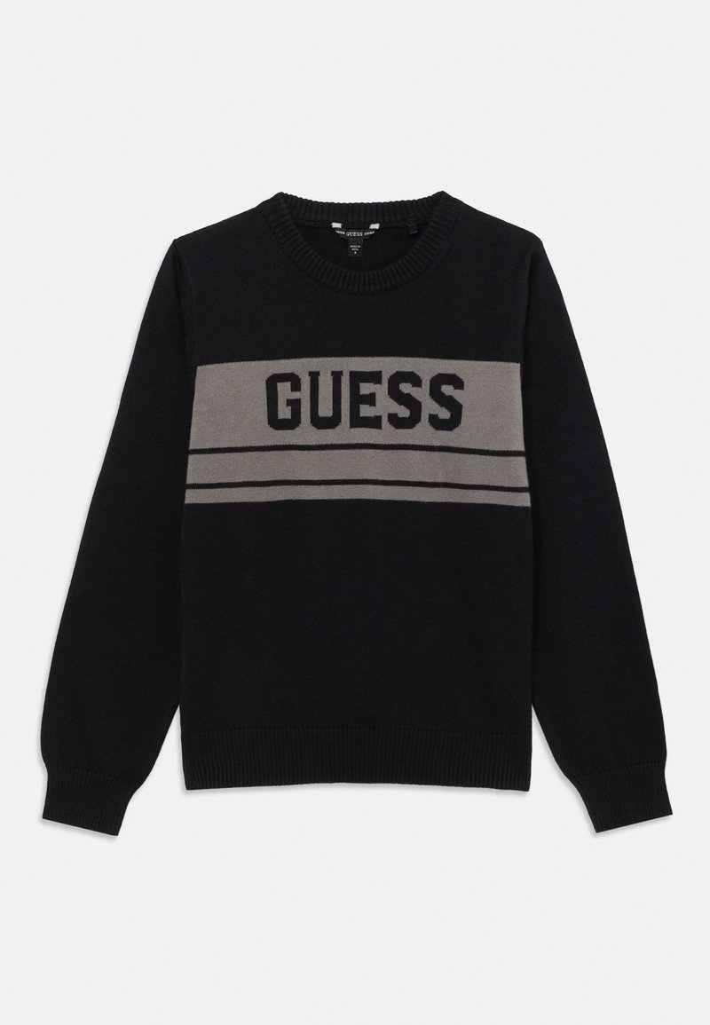 Svart strikkegenser med en grå horisontal stripe og "GUESS" logo i fete svarte bokstaver over brystet. Rund halslinning og ribbestrikkede mansjetter.