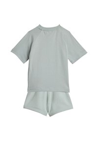 Completo due pezzi in cotone grigio chiaro composto da una maglia a maniche corte con maniche raglan e pantaloncini abbinati con vita elastica.