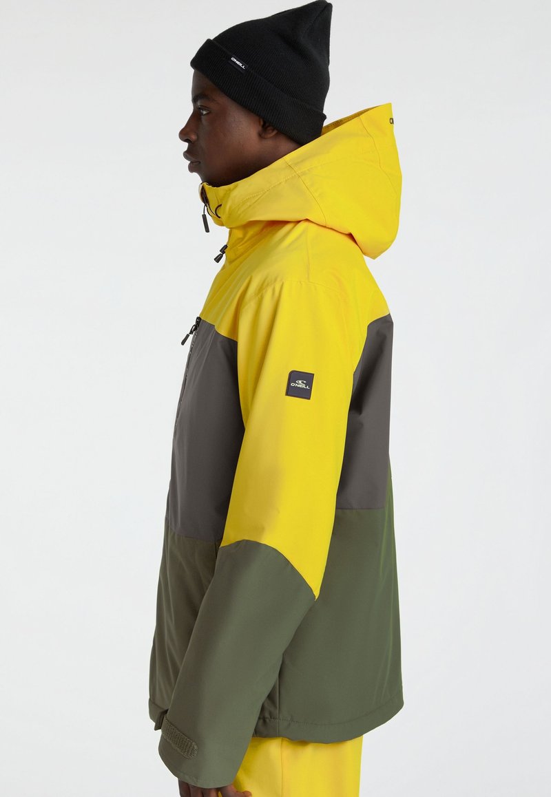 Kolorowa kurtka z panelami w żółtym, szarym i zielonym kolorze. Lekki materiał z kapturem, zamek błyskawiczny i naszywka z logo na rękawie.
