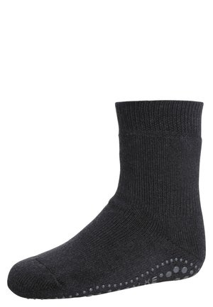Chaussette noire en coton avec texture côtelée, bord replié, et points de grip en caoutchouc sur le dessous pour une meilleure adhérence. Design simple et fonctionnel.