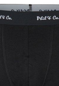 Svarta bomullsboxershorts med ett mjukt midjeband som har varumärket "Phil & Ca" i vit stil. Slät textur och åtsittande design.