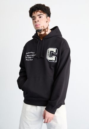 Black hooded sweatshirt with front pocket, embroidered logo on the chest, and white text details. Soft fabric and relaxed fit.