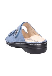 Blue slip-on shoe with a textured upper, circular accents, and a black rubber sole. Features an open back and padded insole for comfort.