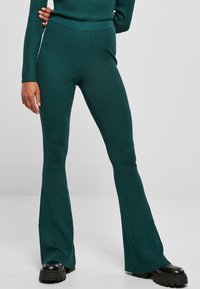 Teal geribde gebreide flared broeken met een hoge taille, featuring een gladde textuur en een strakke pasvorm langs de benen, geaccentueerd door brede openingen aan de zoom.