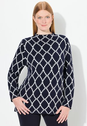 Top en maille bleu marine avec un motif en losanges blancs, col rond, manches longues et coupe décontractée.