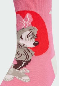 Calzini crew rosa con una finitura testurizzata che presentano un design di un personaggio dei cartoni animati in grigio e rosso su uno sfondo rosa.