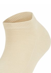 Skarpeta beżowa do kolan z żebrowaną teksturą i elastycznym mankietem. Materiał jest gładki, zaprojektowany z myślą o komforcie i dopasowaniu wokół kostki.