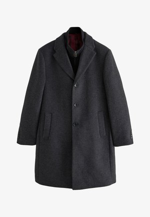 Cappotto in lana grigio scuro con colletto a lancia, chiusura frontale con bottoni e tasche laterali, caratterizzato da una texture liscia e polsini con bottoni.