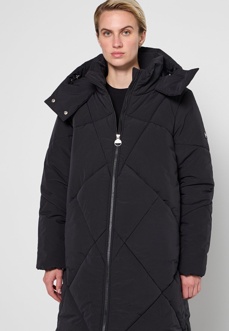 Schwarzer, langer Daunenmantel mit einem gesteppten Rautenmuster, Reißverschluss vorne und einer abnehmbaren Kapuze mit Druckknöpfen. Weiche Textur und voluminöser Schnitt.