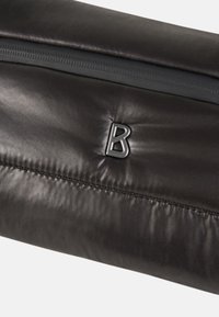 Černá kožená taška s hladkou strukturou, která má výrazné stříbrné logo "B" a zipové uzavření nahoře. Jednoduché detaily prošívání.