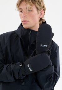 Svart isolerade vantar med en slät yta, med en logopatch och justerbara remmar. I kombination med en svart jacka.